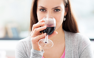 A woman drinking a glass of red wine