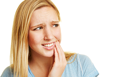 A woman holding the side of her jaw